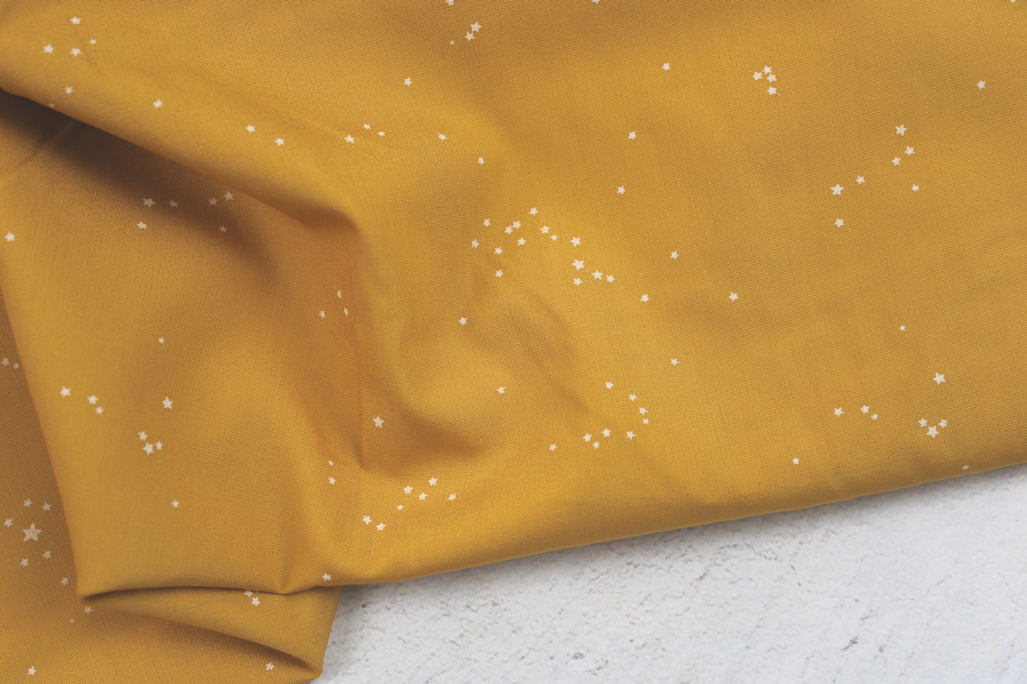 Baumwollstoff Glowdust Golden mit kleinen Sternen aus der Geobloom-Kollektion von Art Gallery Fabrics