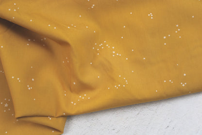 Baumwollstoff Glowdust Golden mit kleinen Sternen aus der Geobloom-Kollektion von Art Gallery Fabrics