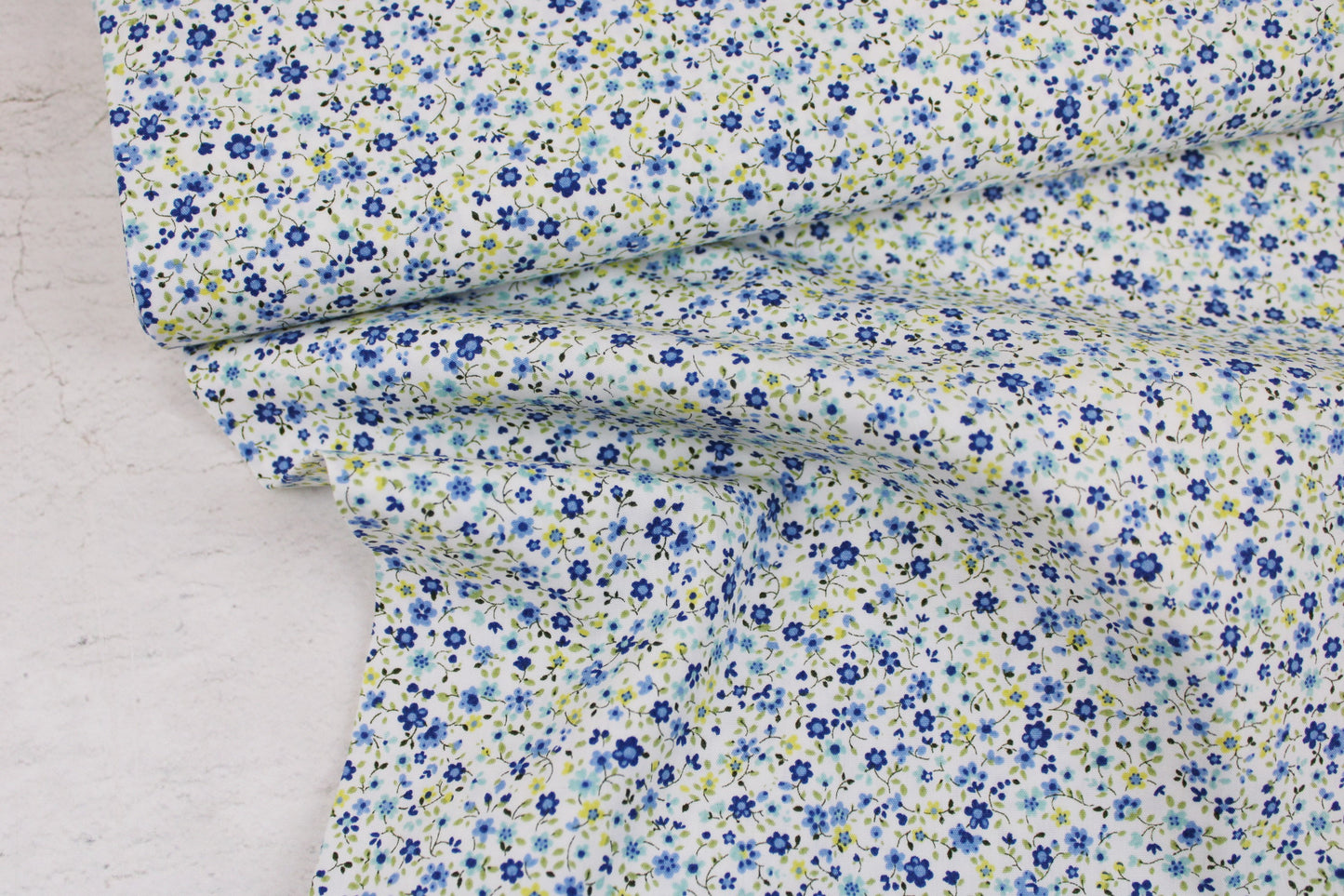 Baumwollstoff Minis mit kleinen Blümchen in Blau auf weißem Grund Ballenansicht