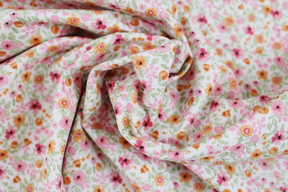 Baumwollstoff Natura mit kleinen Blümchen in Rosa und Orange gedreht