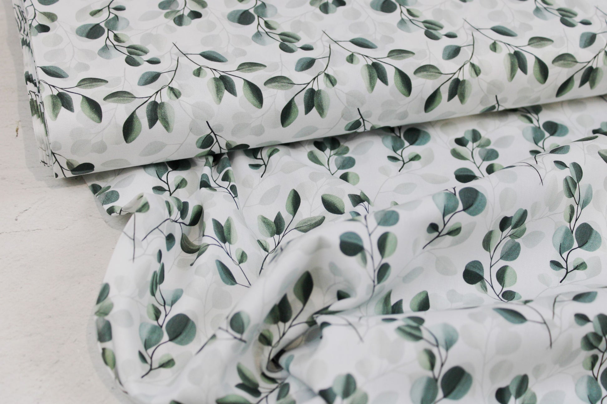 Weißer Baumwollstoff mit salbei farbenen Blättern/Eukalyptus Ballenansicht