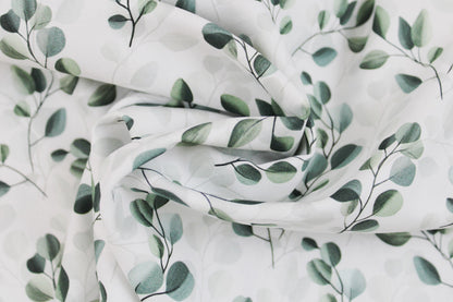 Weißer Baumwollstoff mit salbei farbenen Blättern/Eukalyptus gedreht