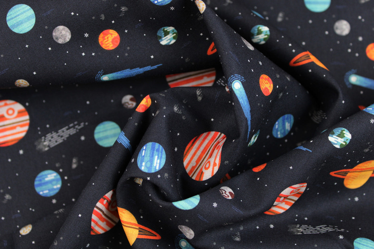 Dunkelblauer Baumwollstoff Tim mit buntem Weltallmuster gedreht