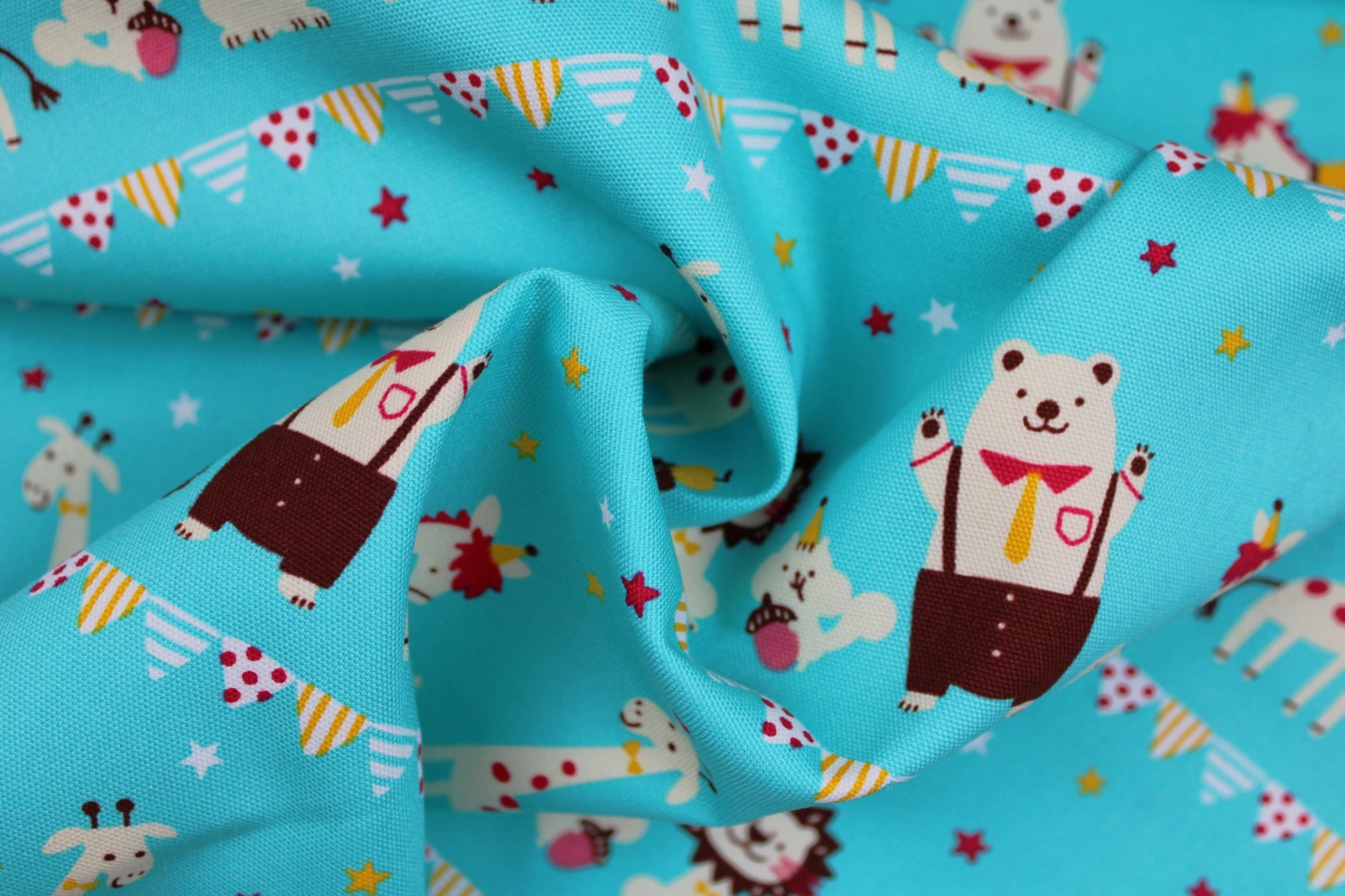 Türkis farbener Baumwollstoff mit Tiermotiven gedreht