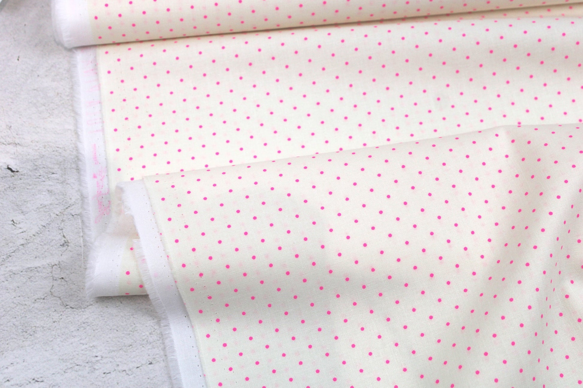 Wollweißer Baumwollstoff True Colors Tiny Dots mit Pink farbenen Punkten  Ballenansicht