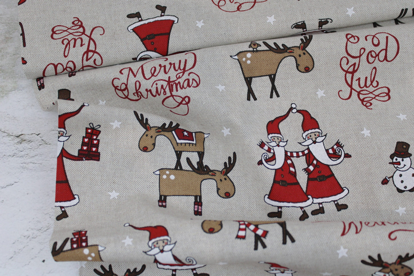 Canvasstoff Emil mit fröhlichen Weihnachtsmotiven auf beigem Grund Ballenansicht