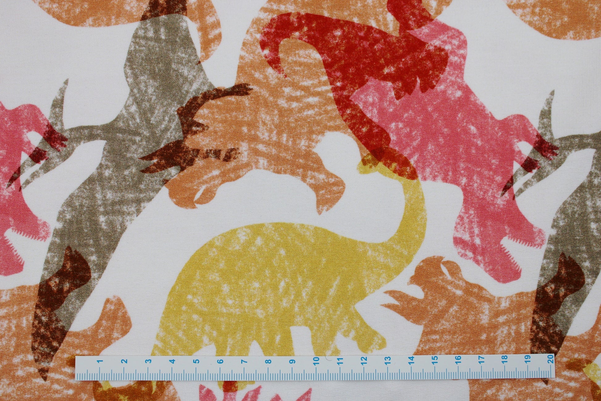 Heller French Terry Sweat mit Dinosauriern in Rot, Gelb und Orange Maßstab