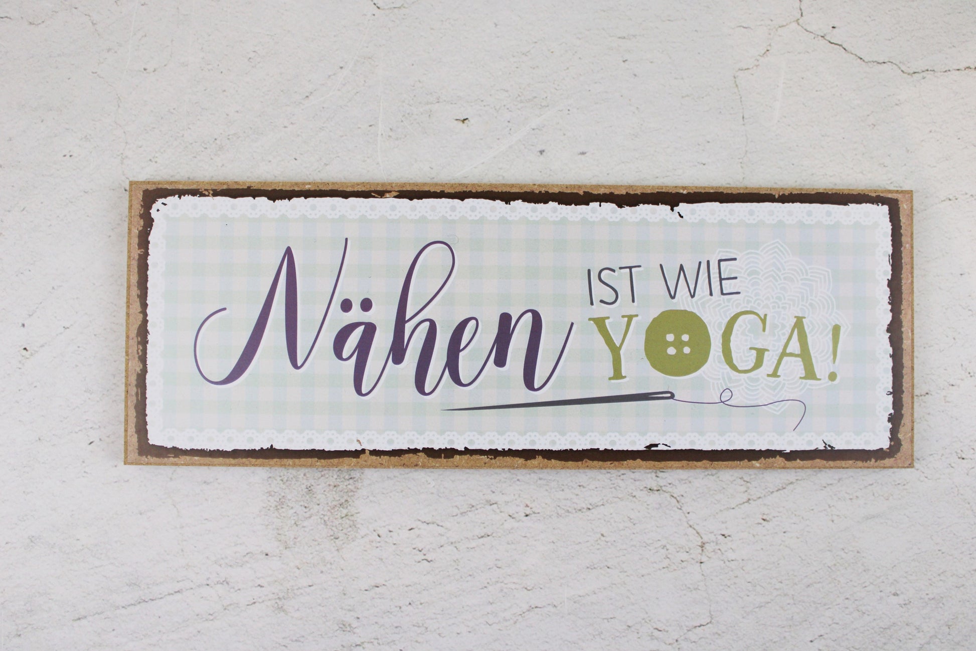 Holzschild mit dem Nähspruch "Nähen ist wie Yoga"