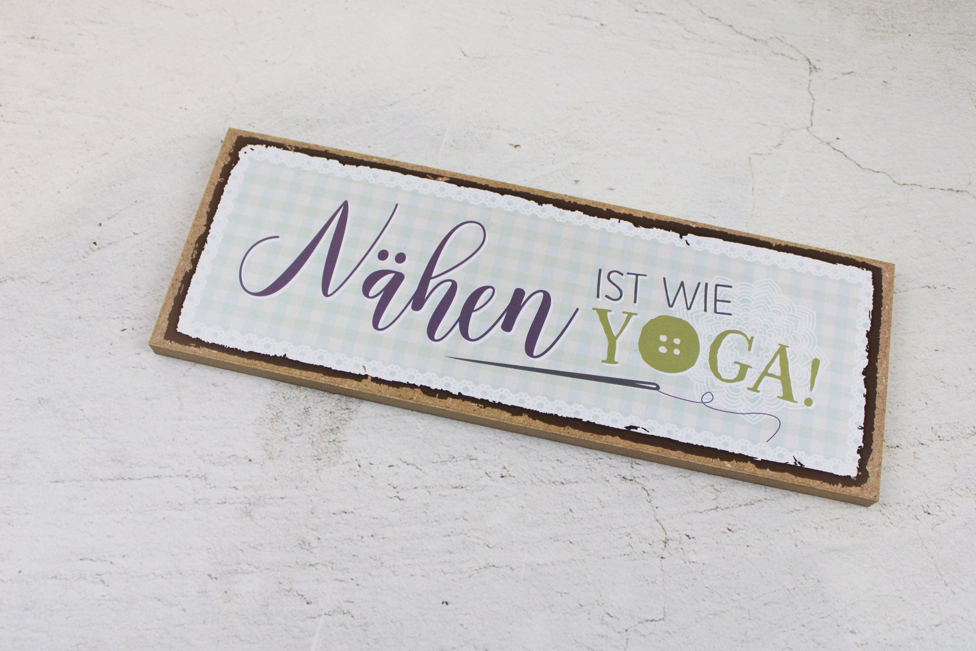 Holzschild mit dem Nähspruch "Nähen ist wie Yoga"