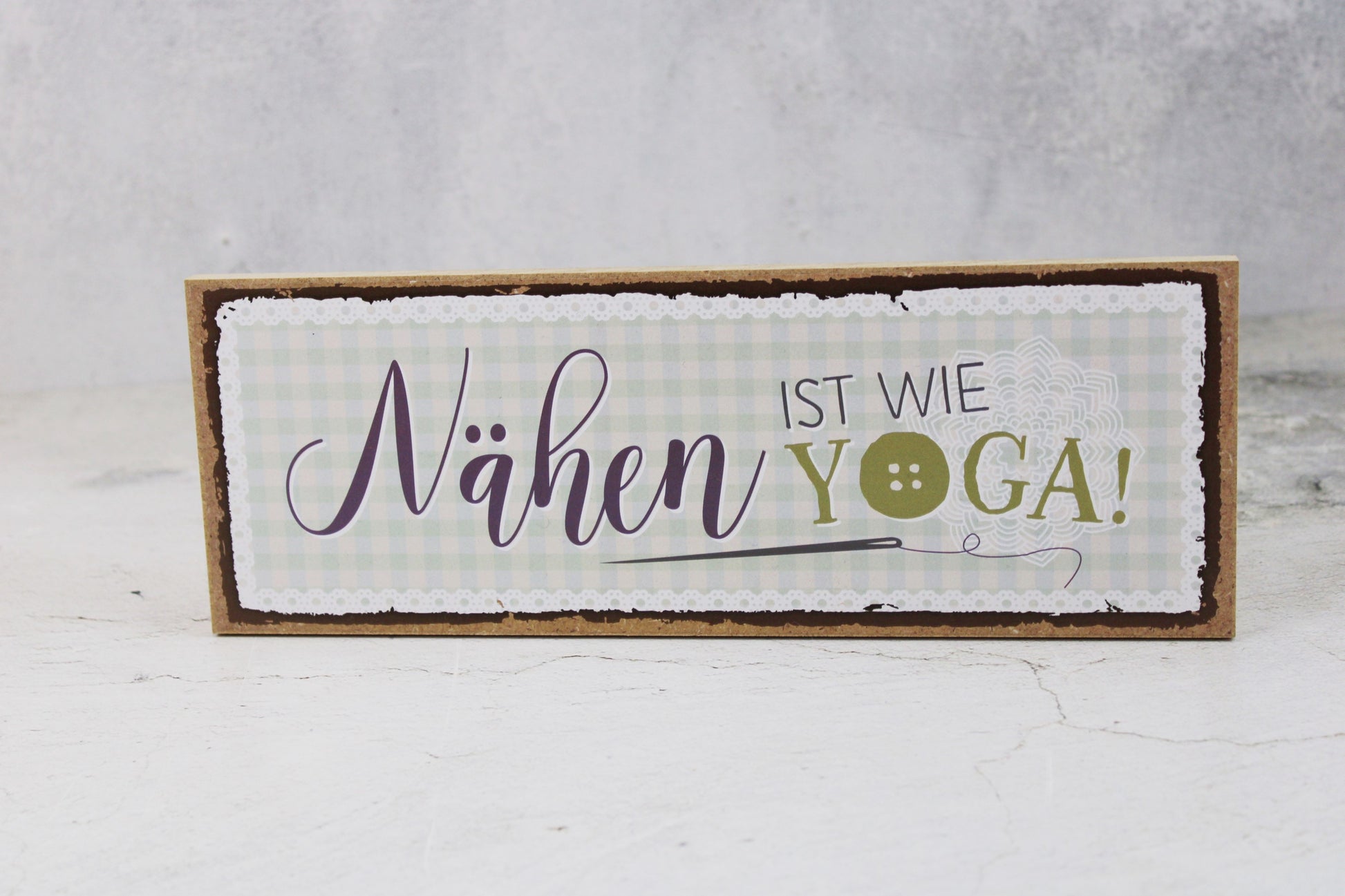 Holzschild mit dem Nähspruch "Nähen ist wie Yoga"
