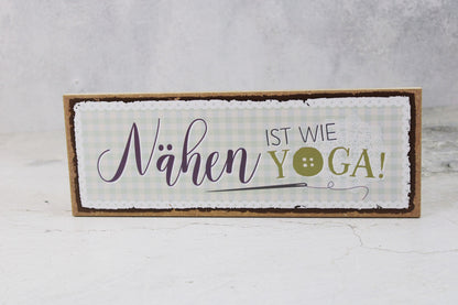 Holzschild mit dem Nähspruch "Nähen ist wie Yoga"