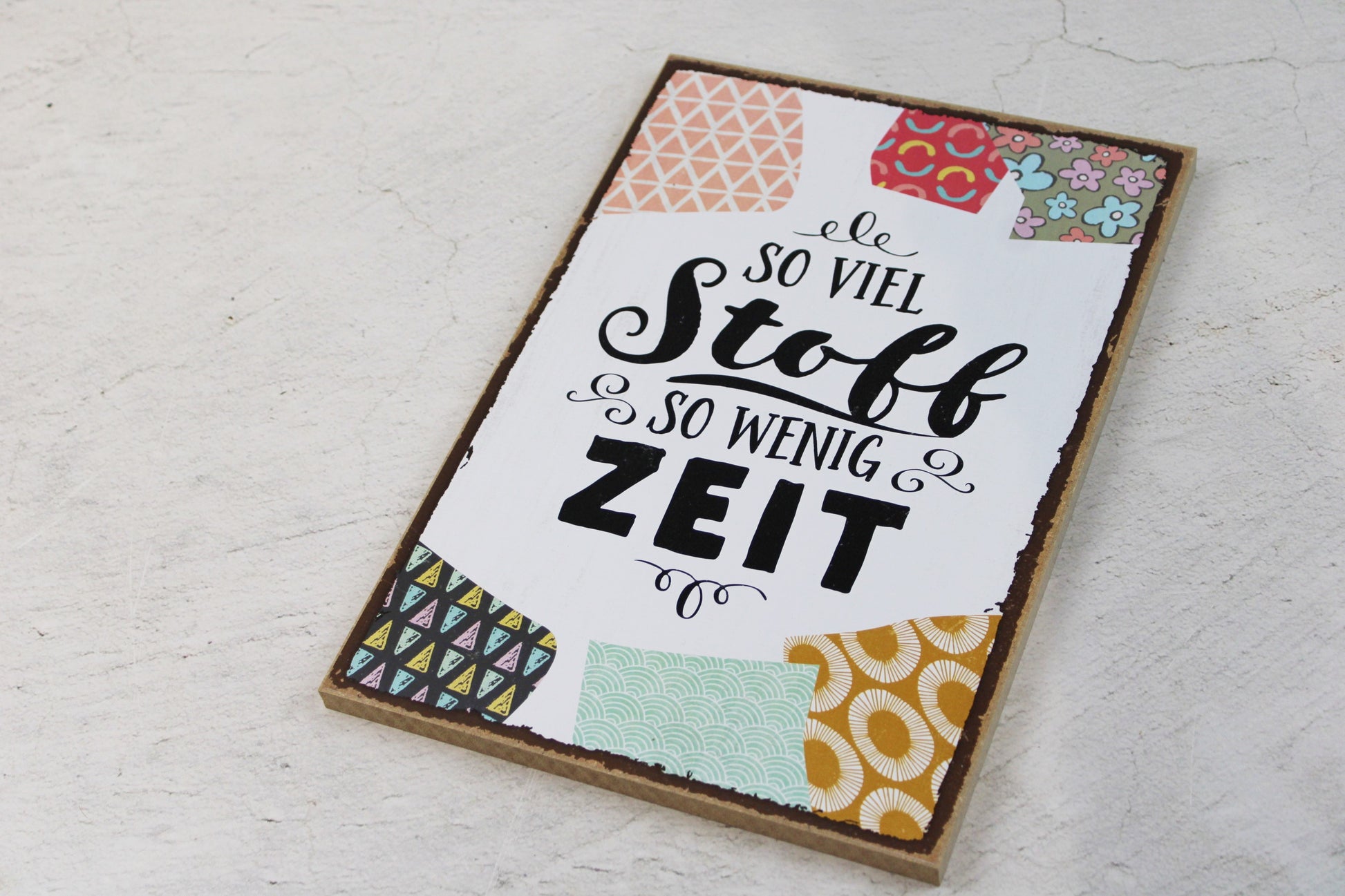 Holzschild mit dem Nähspruch "So viel Stoff, so wenig Zeit"