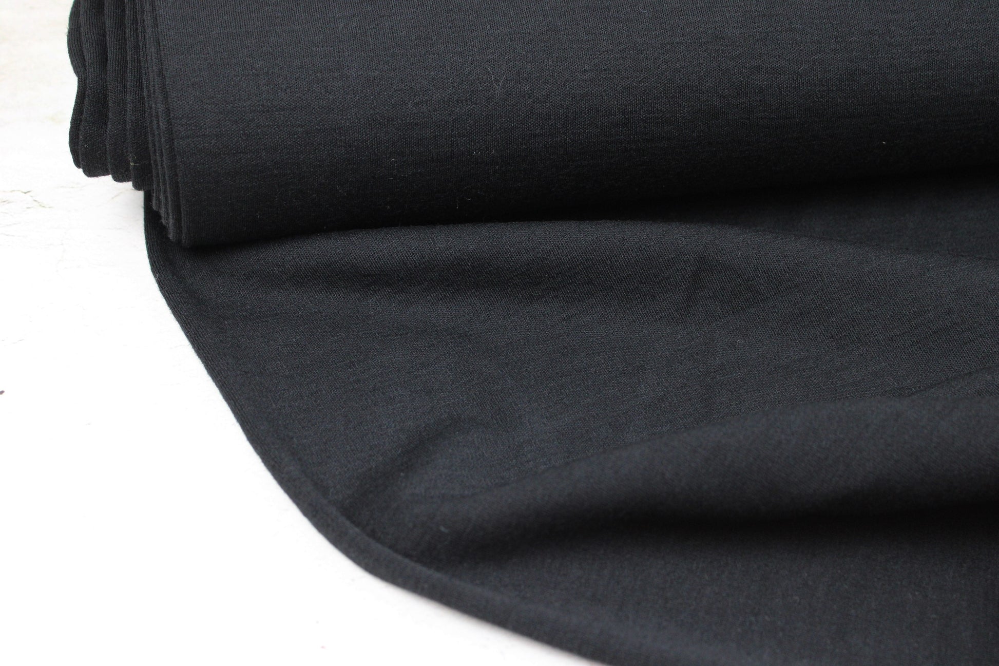 Merinostrickstoff Wolljersey in uni Schwarz Ballenansicht