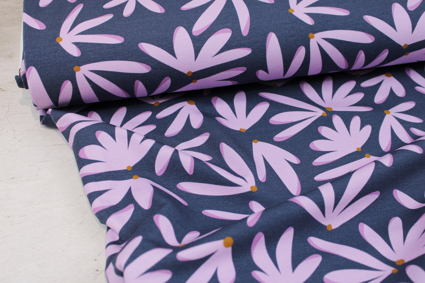 Modal Sommersweat Hannah mit flieder farbenen Blumen auf blauem Grund Ballenansicht