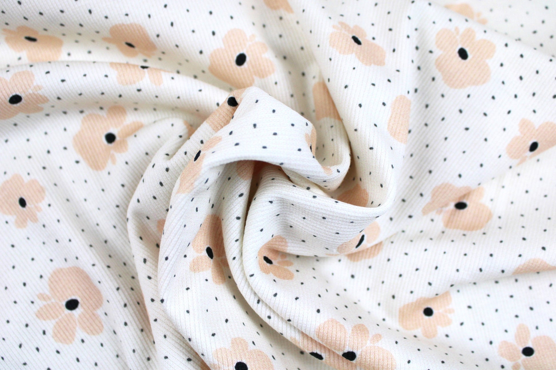 Wollweißer Rippjersey Jena mit kleinen Blüten in Apricot gedreht