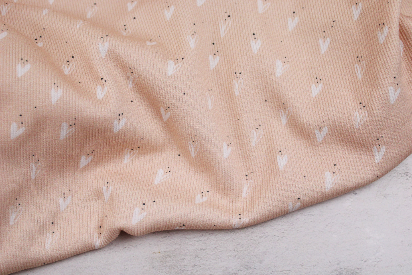 Rippjersey Jena mit hellen Herzen auf apricot farbeneme Grund