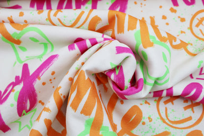 Heller Sweatstoff mit Graffitimuster in Neonfarben gedreht