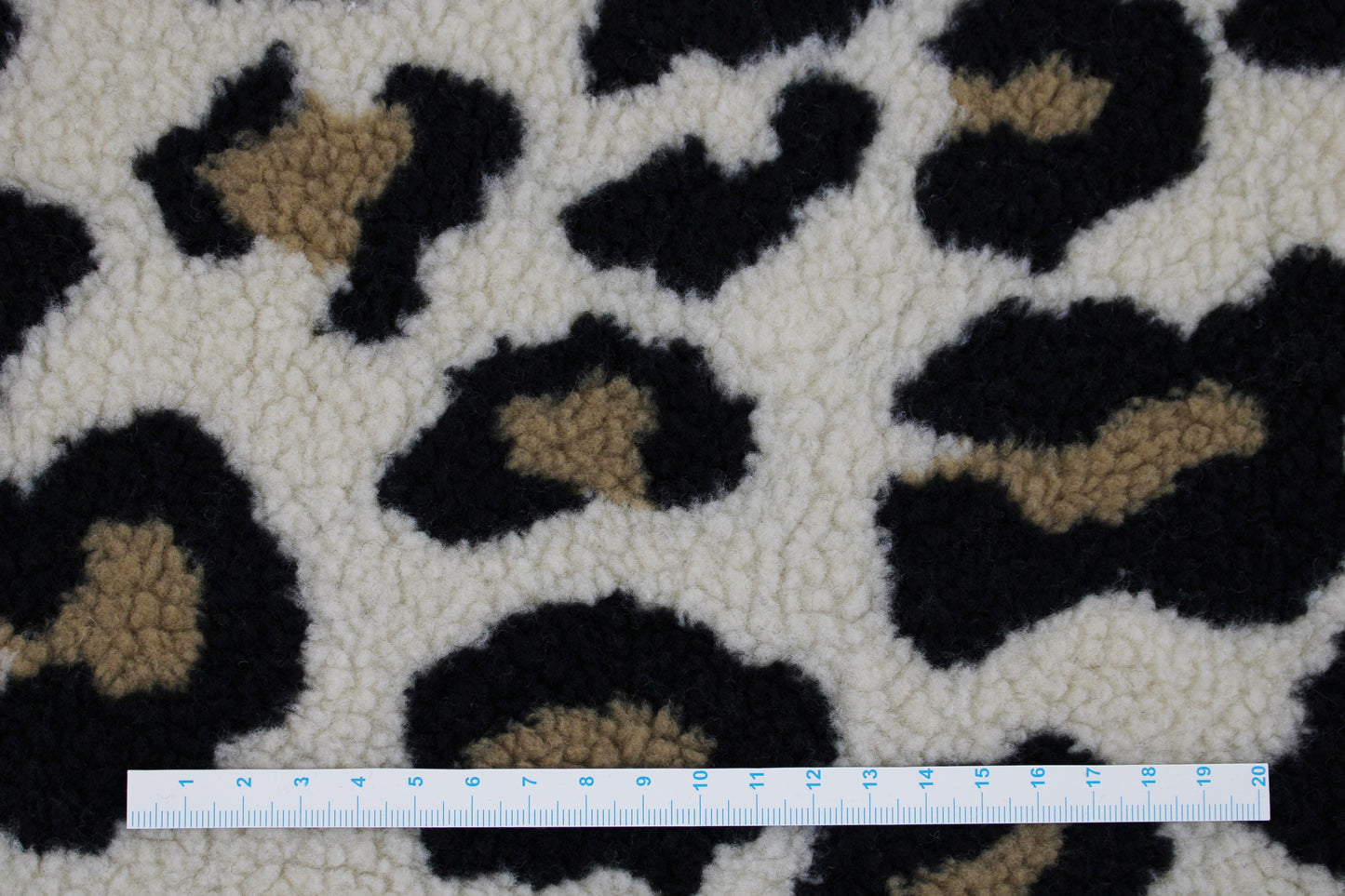 Teddystoff mit Leoprint in beige Maßstab