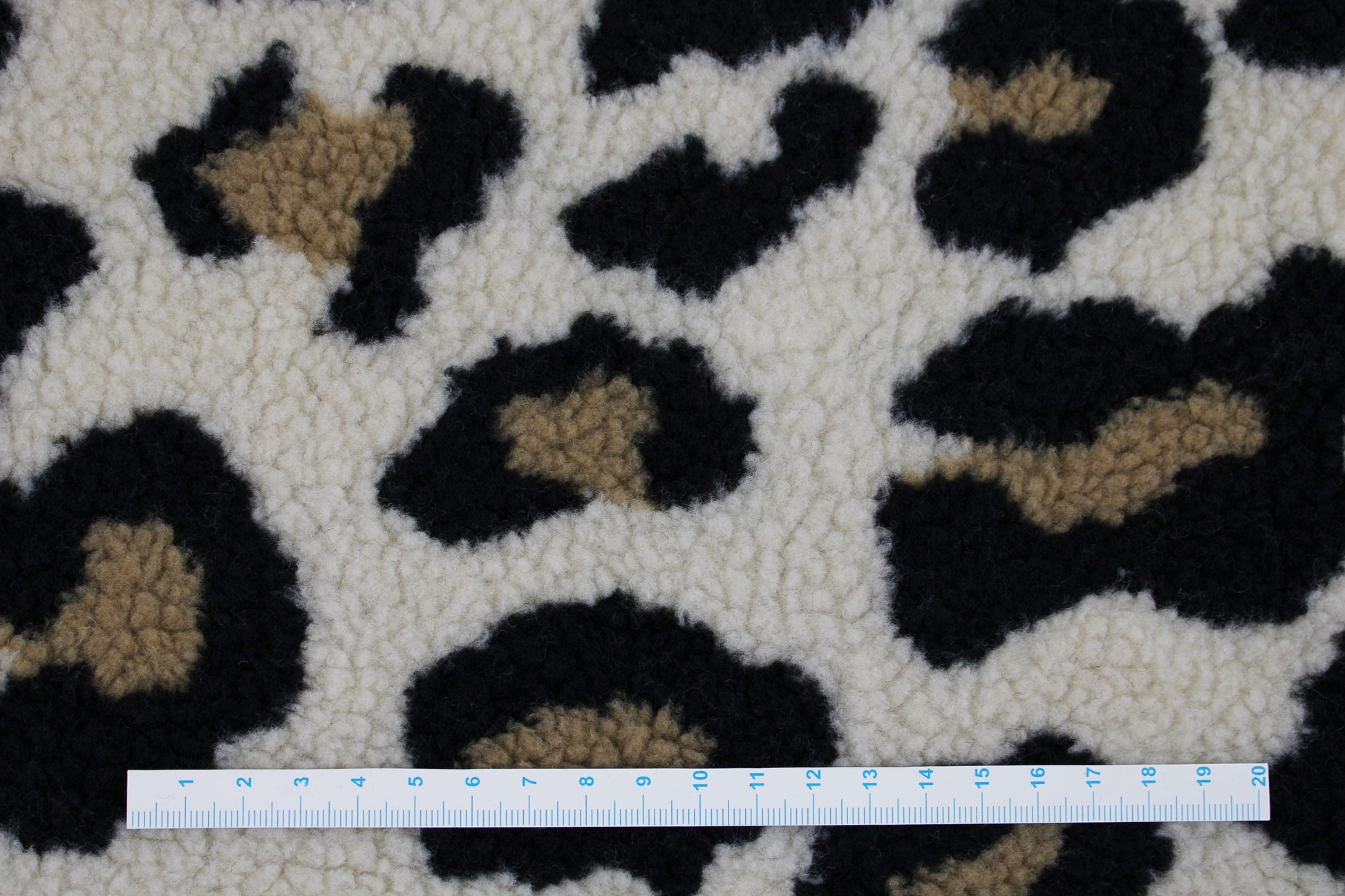 Teddystoff mit Leoprint in beige Maßstab