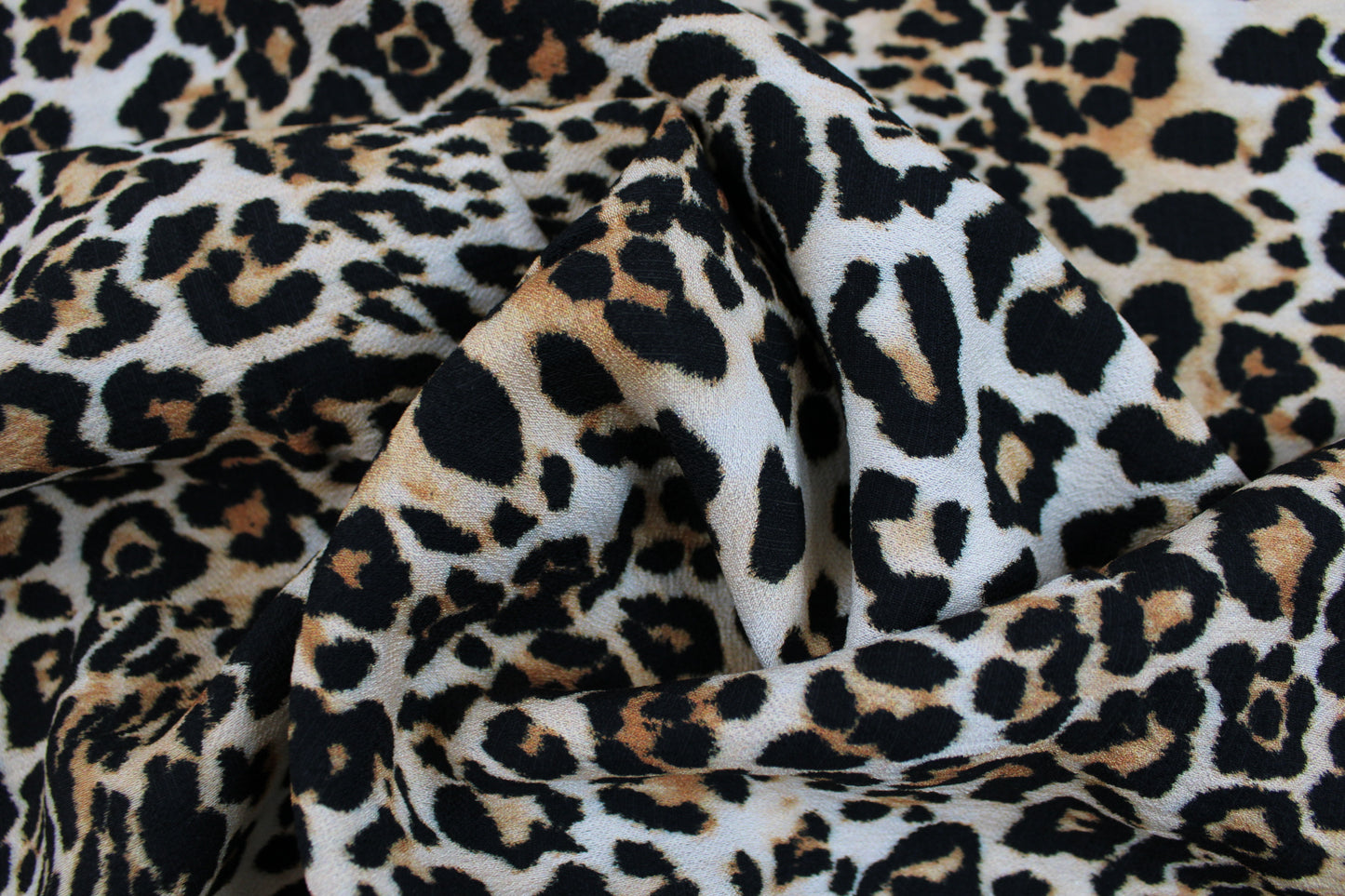 Viskosecrepe Stoff mit klassischem Leoprint in Beigetönen gedreht