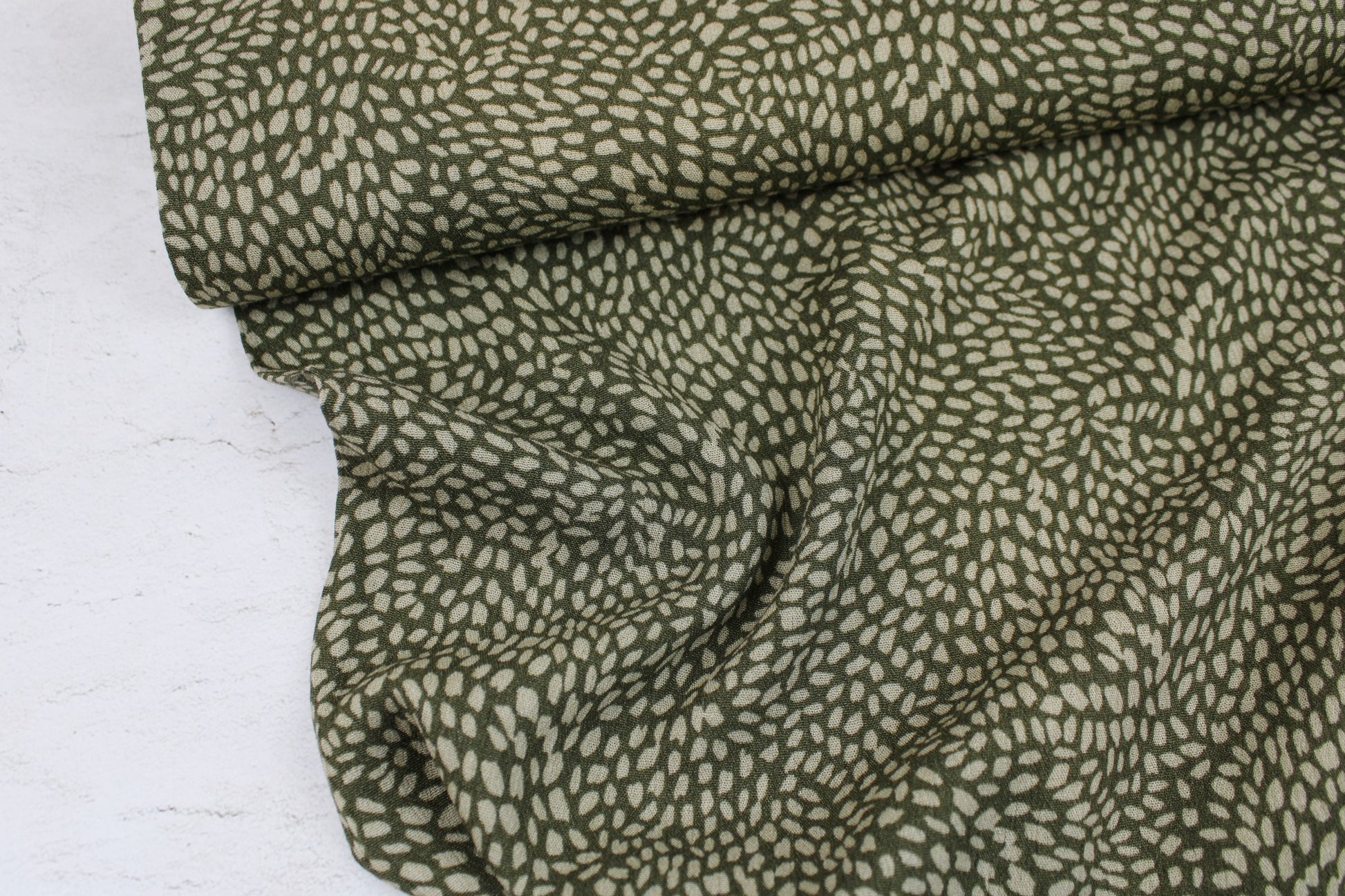 Viskosecrepestoff mit kleinem Punktemuster in Khaki und Oliv Ballenansicht