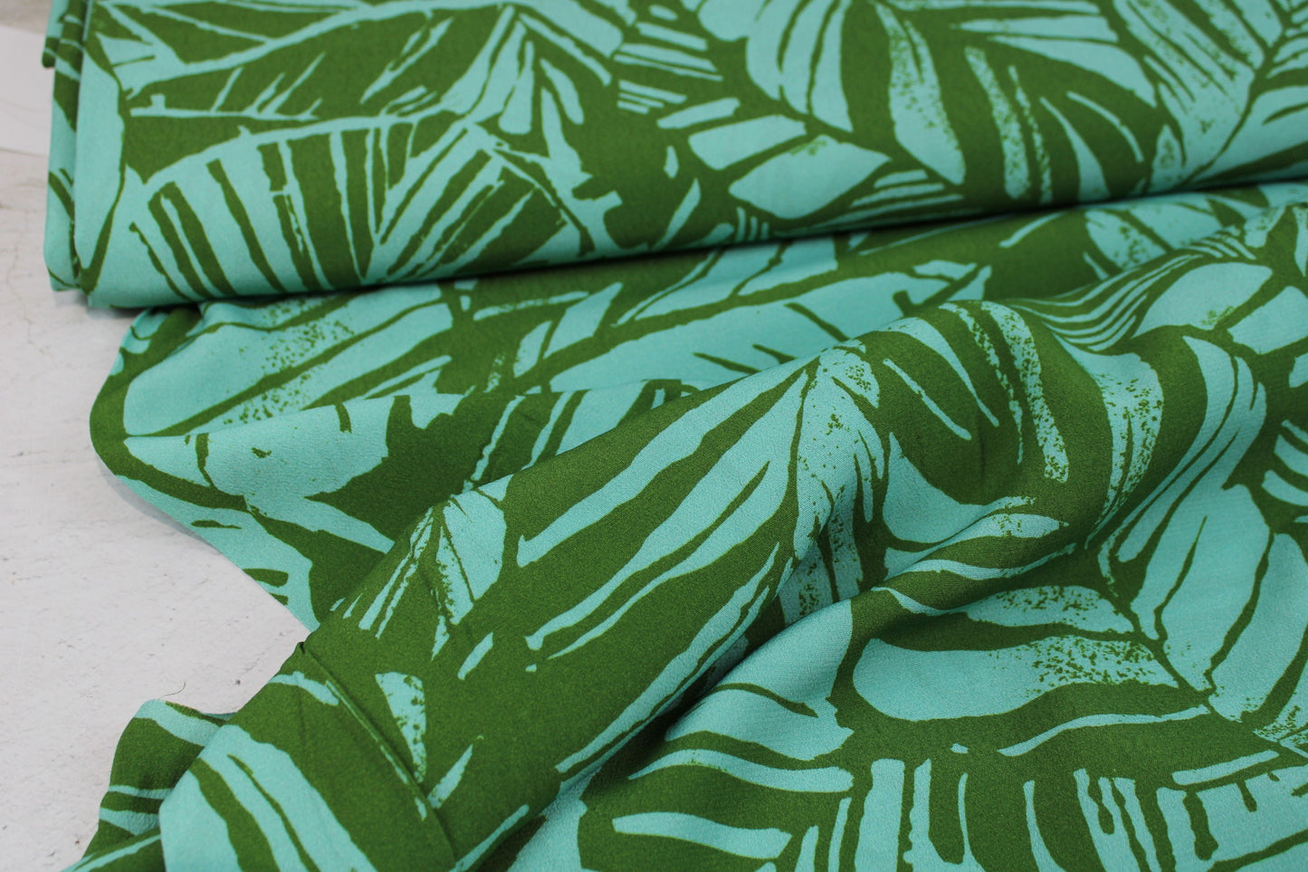 Leichter Viskosecrepestoff mit Blättermotiv in Oliv und Mint Ballenansicht