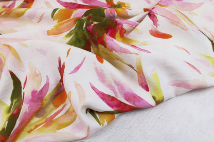Viskosecrepe Mango mit bunten Blüten auf wollweißem Grund