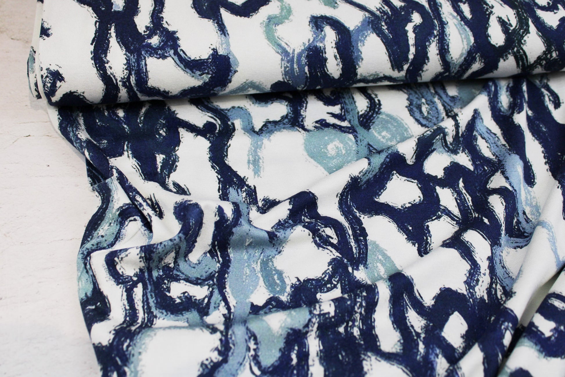 Viskosejersey mit abstrakten Linien in Blau auf weißem Grund Ballenansicht