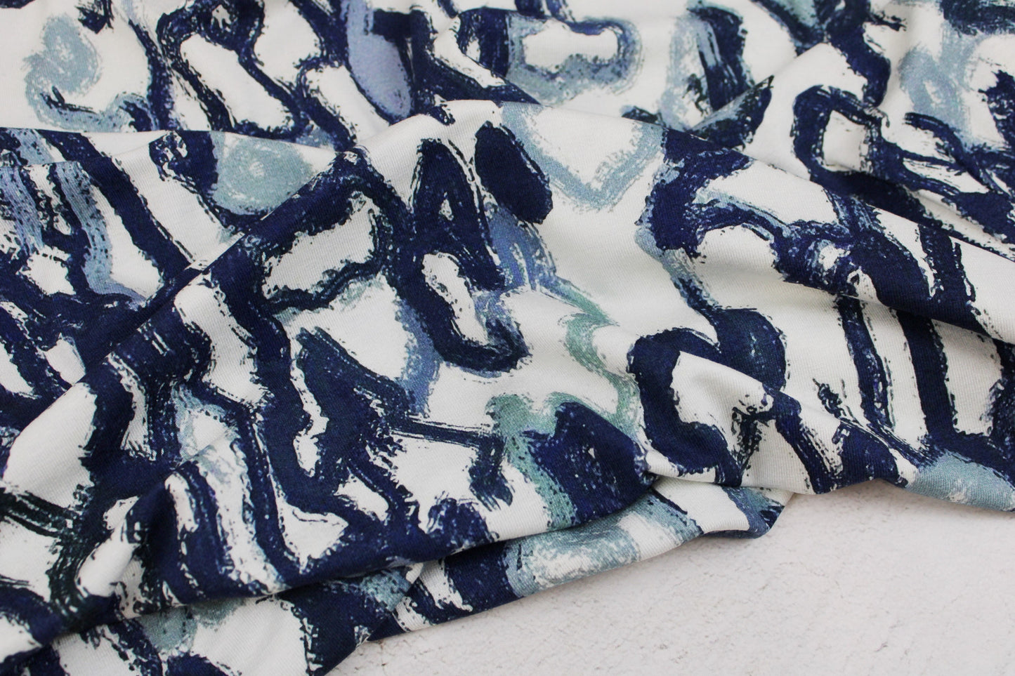 Viskosejersey mit abstrakten Linien in Blau auf weißem Grund