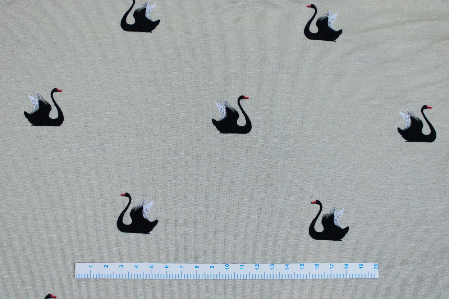 Weich fallender Viskosejersey in beige mit Schwänen Maßstab