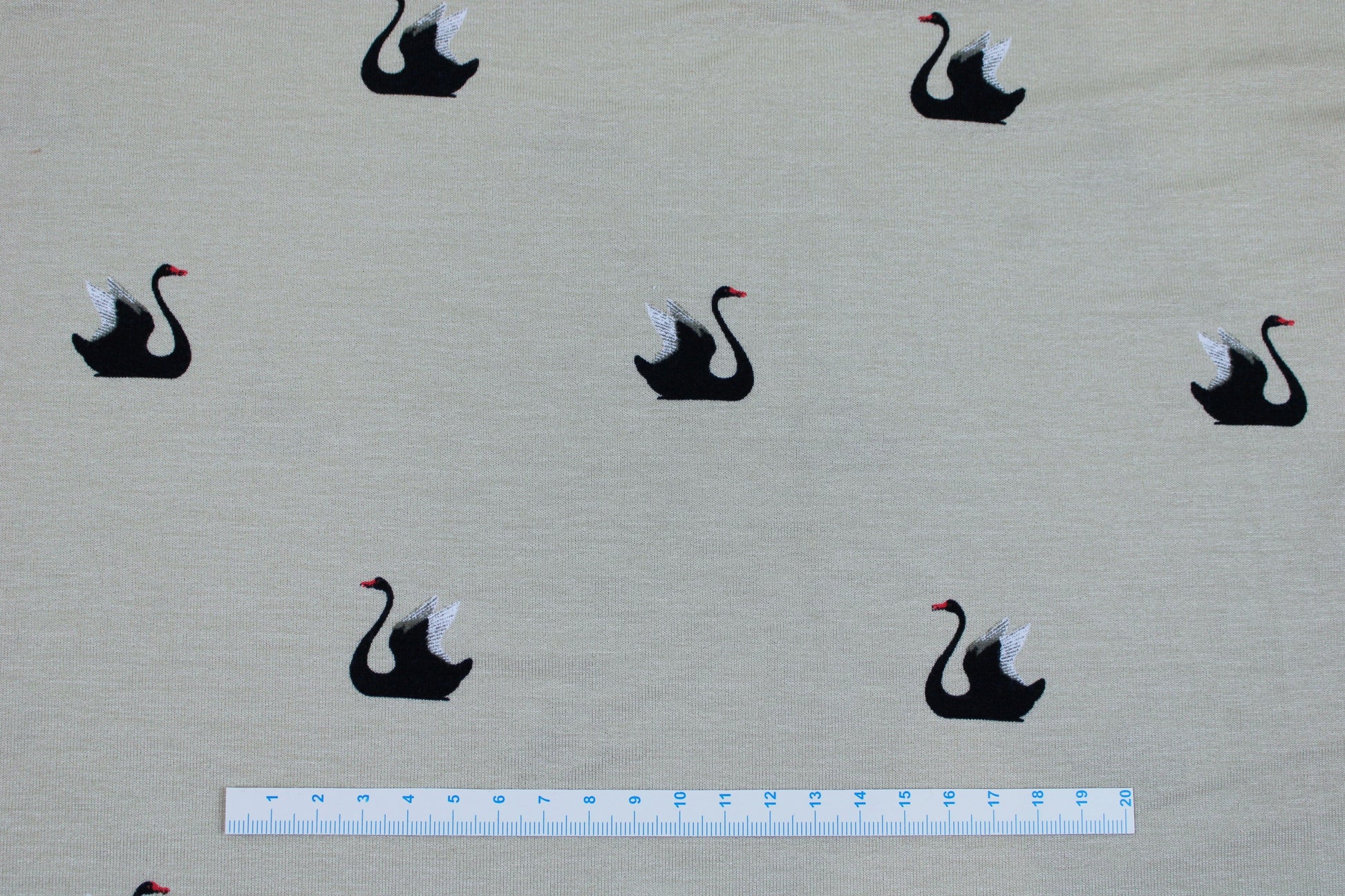 Weich fallender Viskosejersey in beige mit Schwänen Maßstab