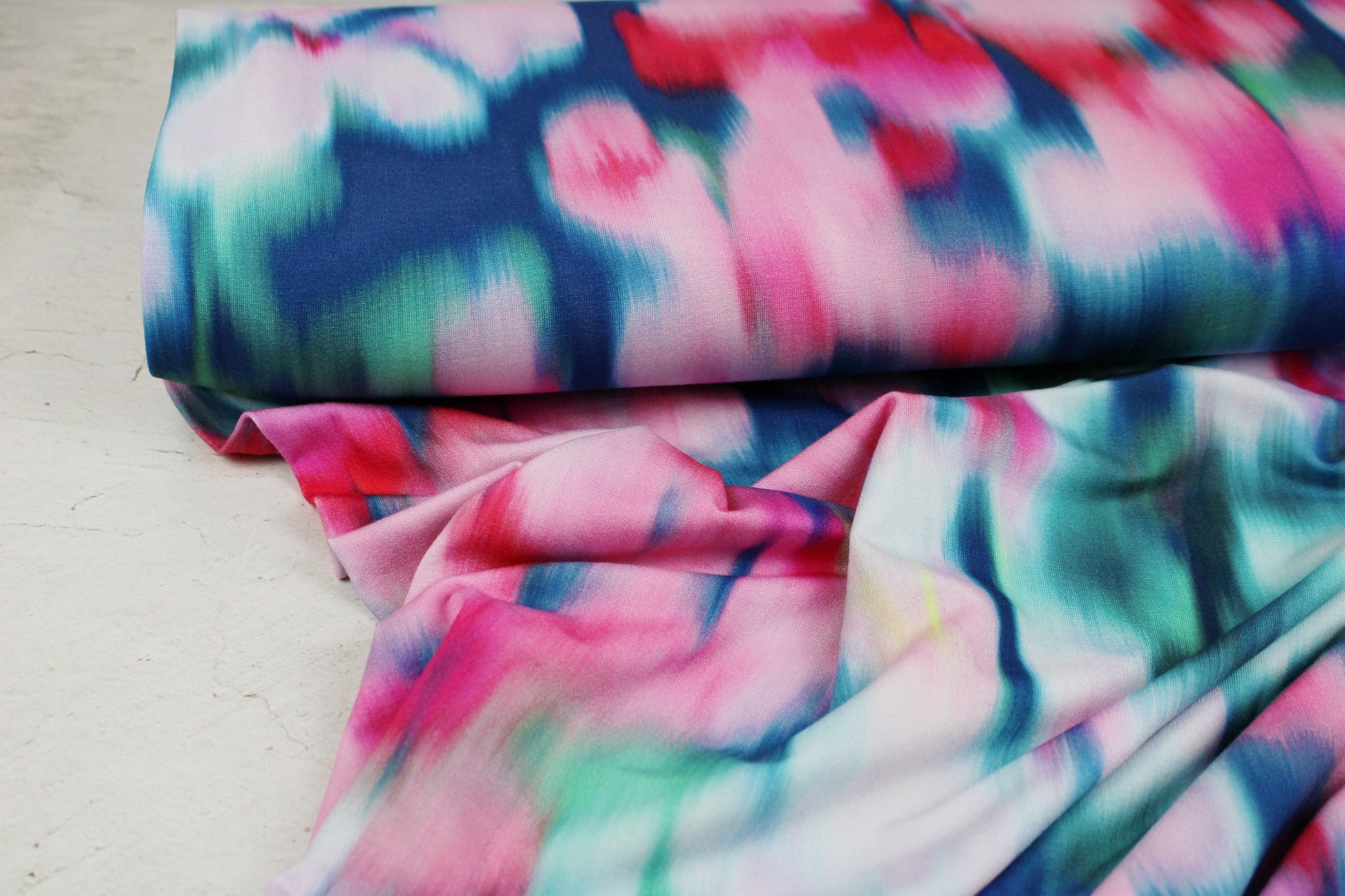 Viskosejersey Sizilien mit abstraktem Blumenmuster in Petrol und Pink Ballenansicht