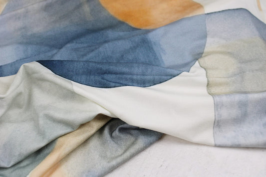 Viskosejersey mit großen geometrischen Formen in Blau und Rost auf hellem Grund