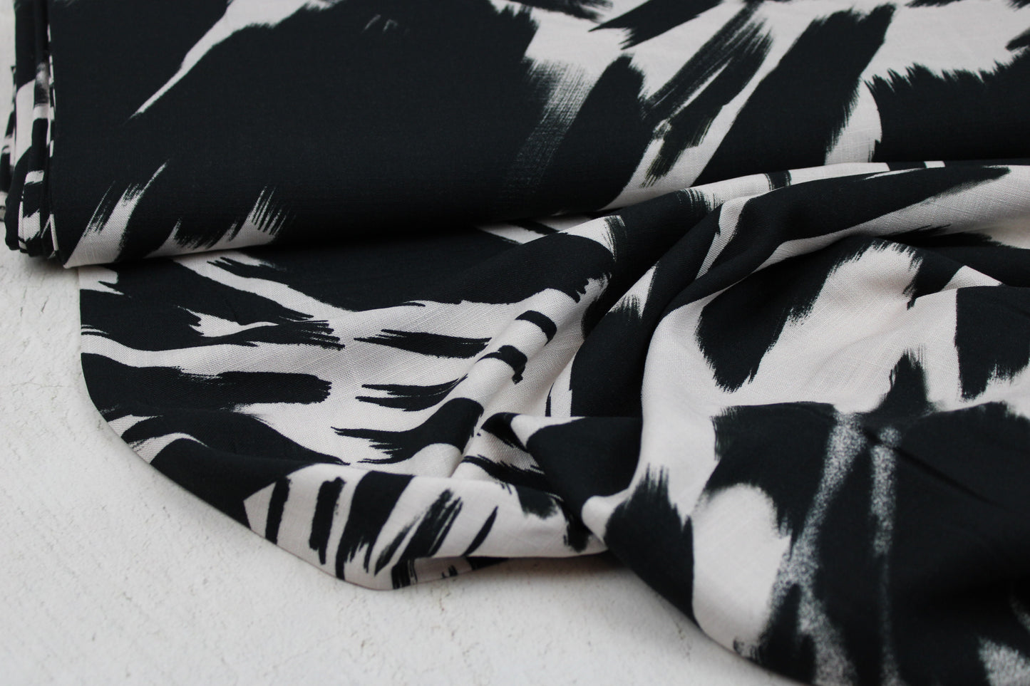 Leicht fließender Viskosestoff mit Pinselstrichmuster in Schwarz-Ecru Ballenansicht