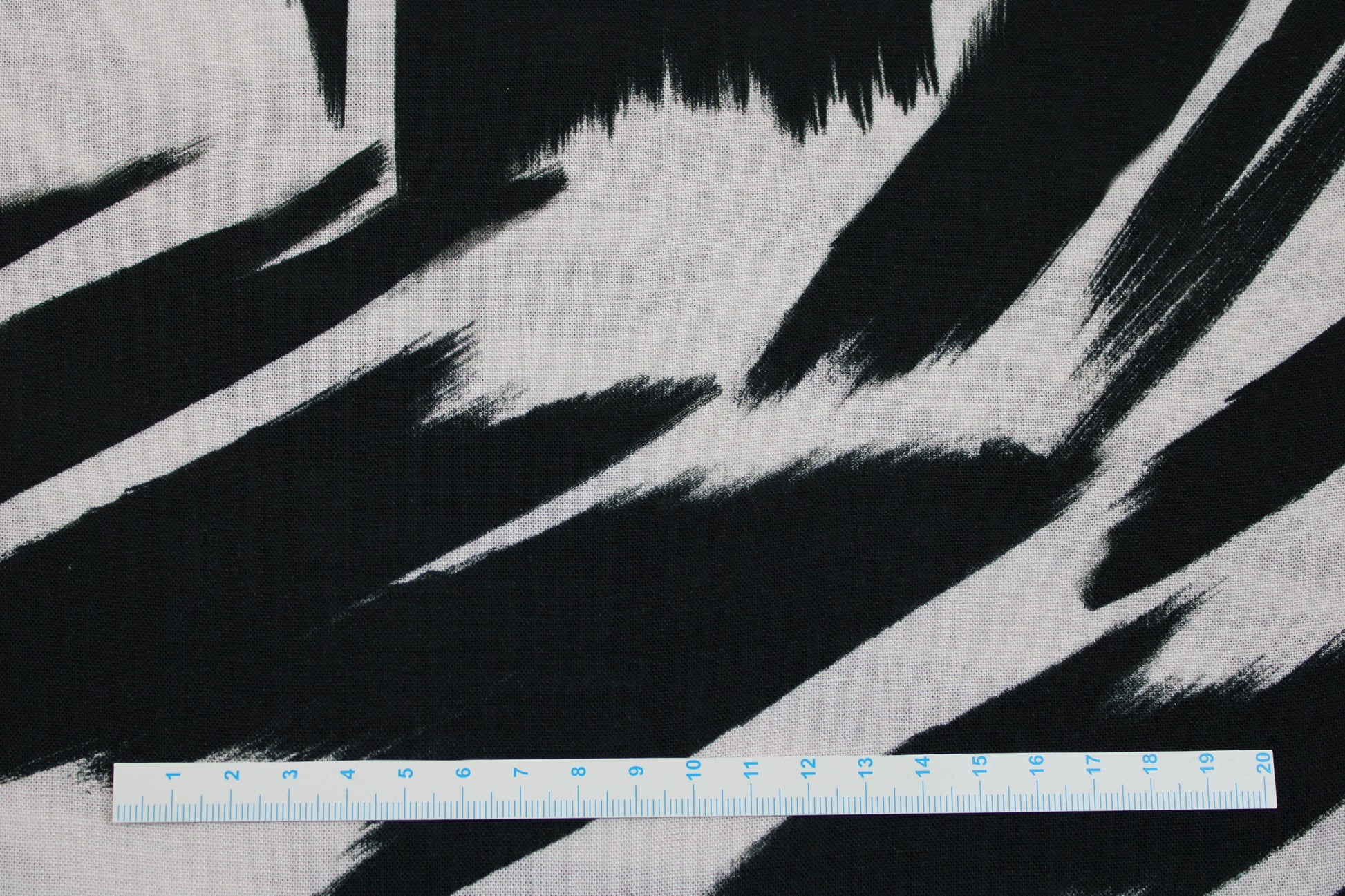 Leicht fließender Viskosestoff mit Pinselstrichmuster in Schwarz-Ecru Maßstab