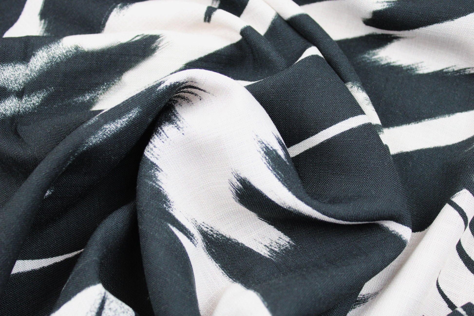 Leicht fließender Viskosestoff mit Pinselstrichmuster in Schwarz-Ecru gedreht