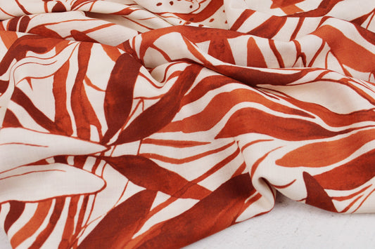 Wollweißer Viskosestoff mit großem Blättermuster in orange