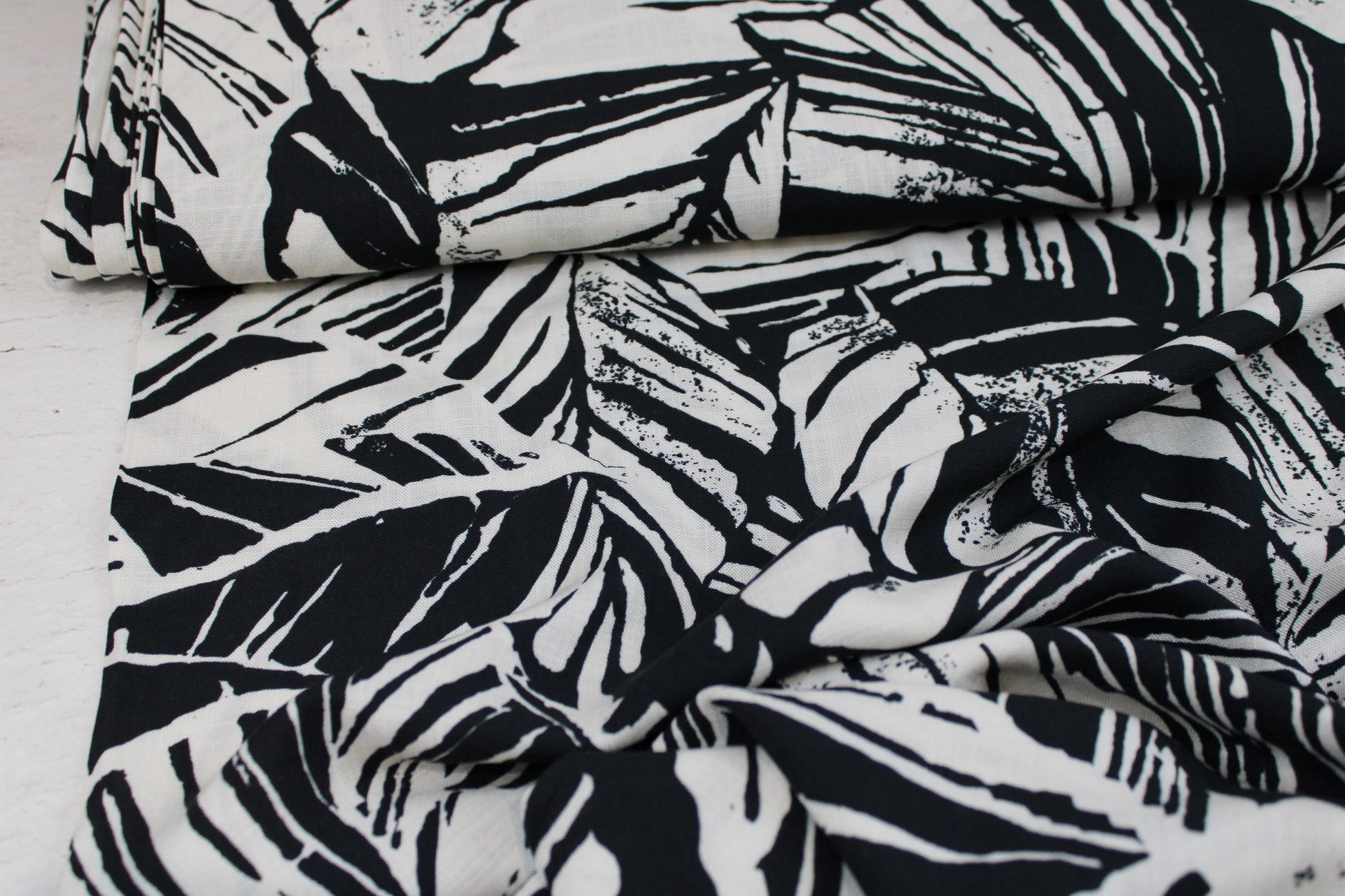 Viskosestoff mit Blättermuster und Leinenstruktur in Schwarz und Wollweiß Ballenansicht