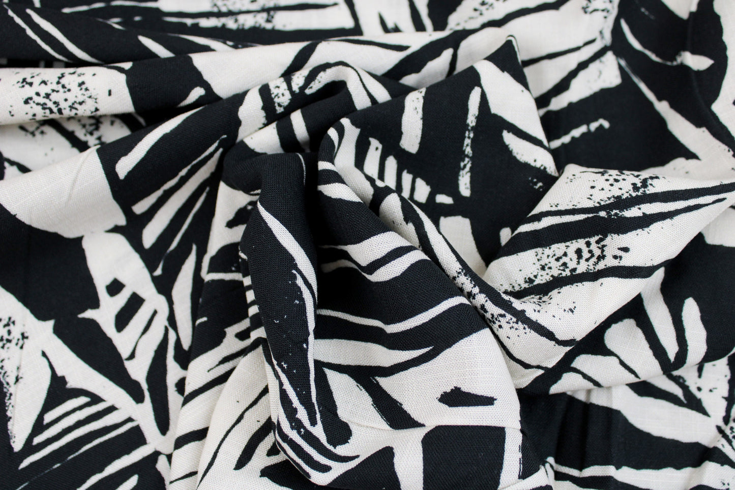 Viskosestoff mit Blättermuster und Leinenstruktur in Schwarz und Wollweiß gedreht