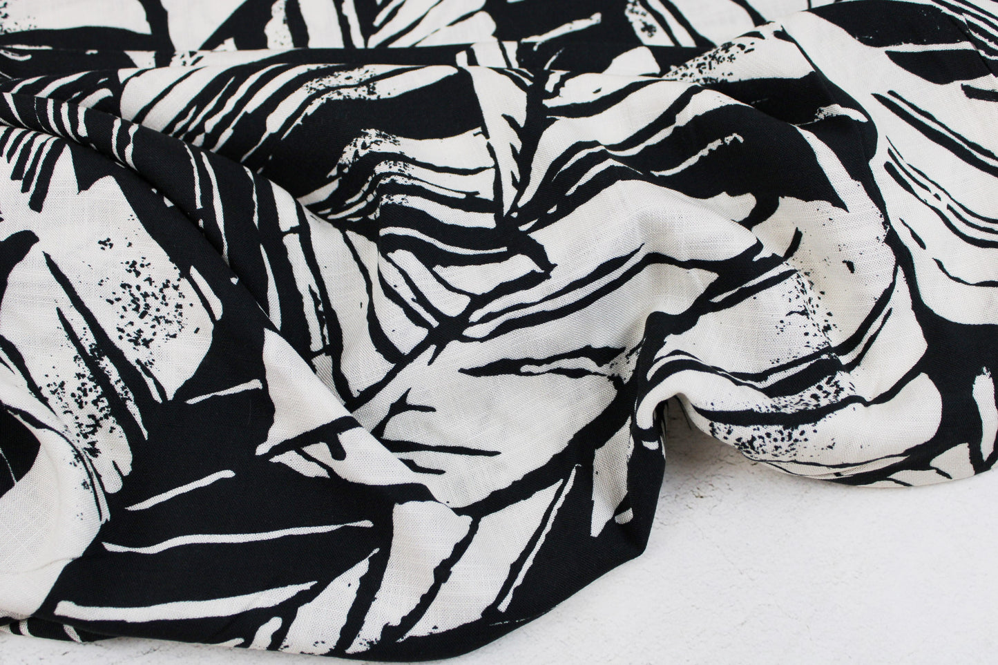 Viskosestoff mit Blättermuster und Leinenstruktur in Schwarz und Wollweiß
