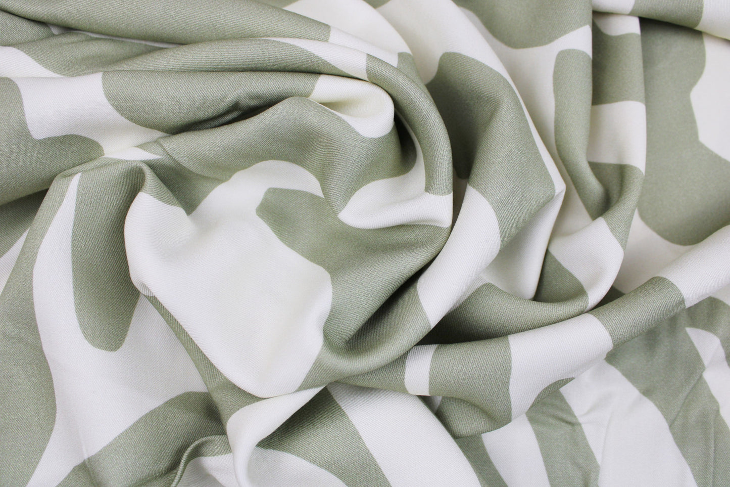 Viskosestoff mit abstrakten Linien in Ecru und Lindgrün von Light & Lush gedreht