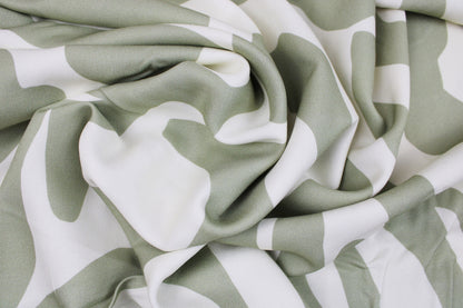 Viskosestoff mit abstrakten Linien in Ecru und Lindgrün von Light & Lush gedreht