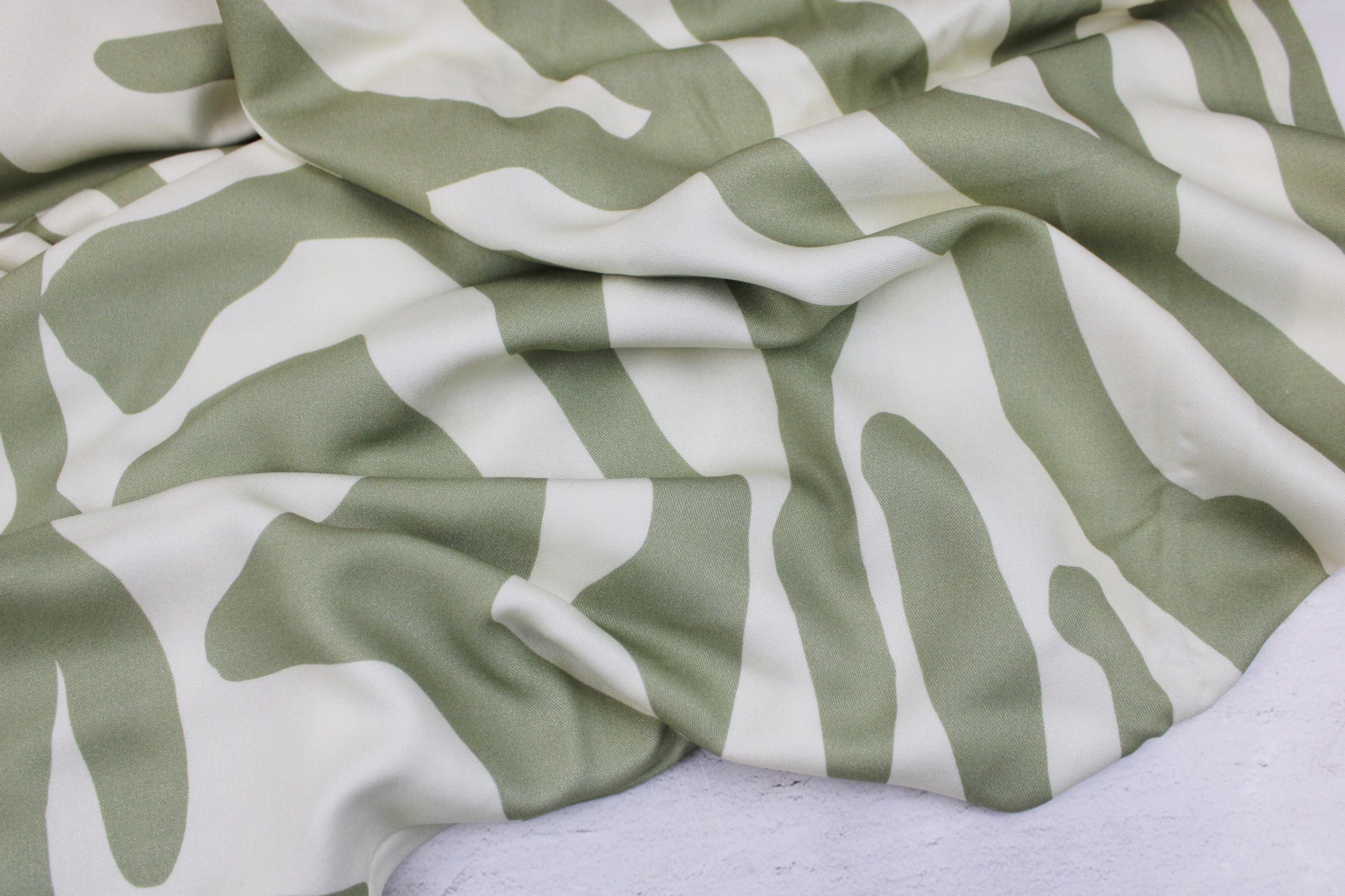 Viskosestoff mit abstrakten Linien in Ecru und Lindgrün von Light & Lush