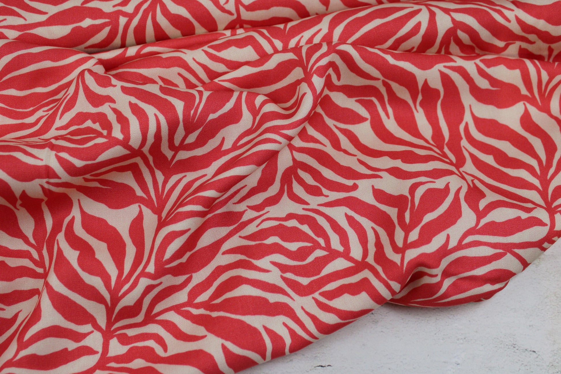 Viskosestoff Zebra Jungle mit Blätterprint in Koralle und Ecru