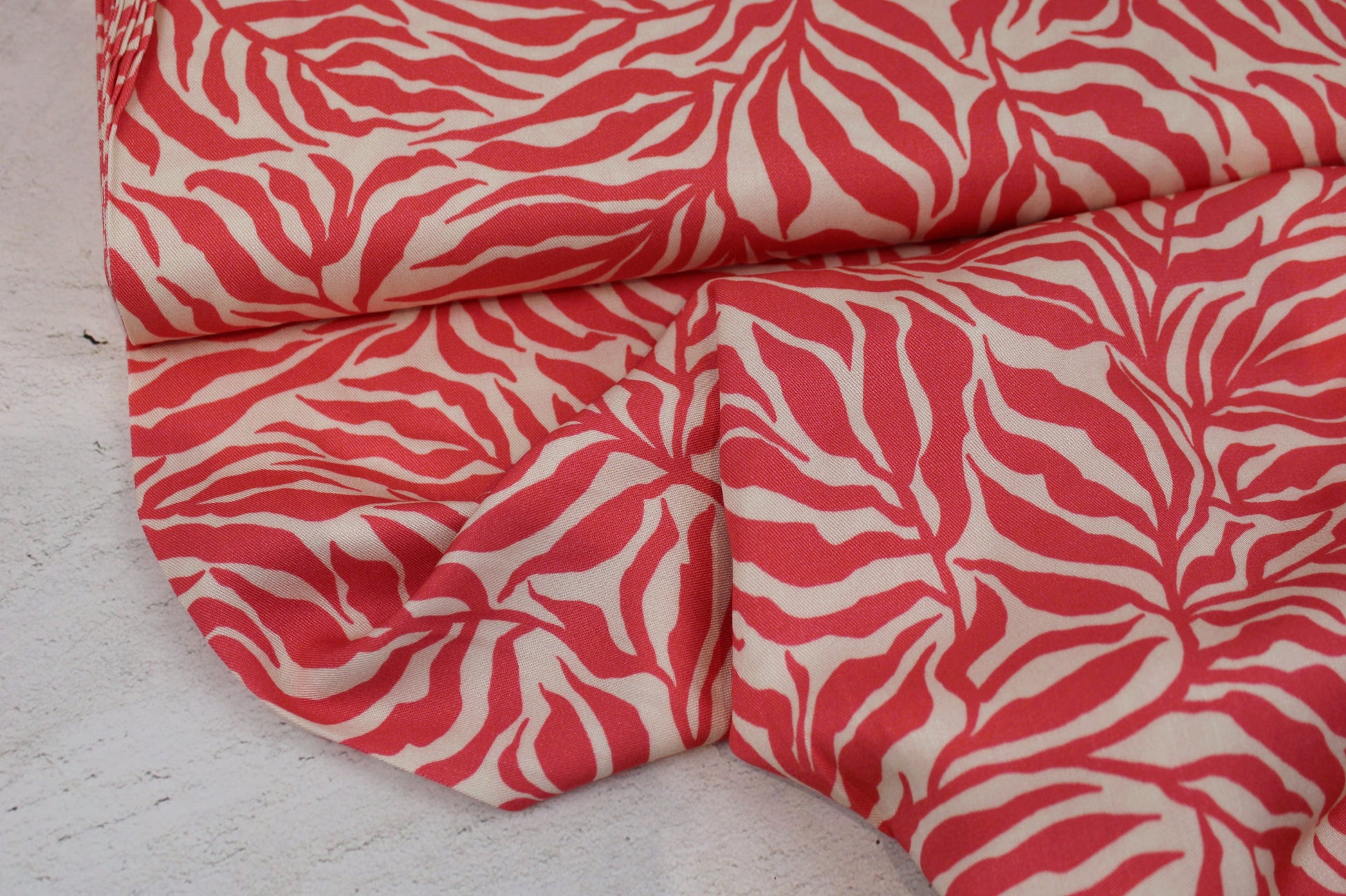 Viskosestoff Zebra Jungle mit Blätterprint in Koralle und Ecru Ballenansicht