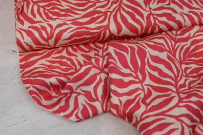 Viskosestoff Zebra Jungle mit Blätterprint in Koralle und Ecru Ballenansicht
