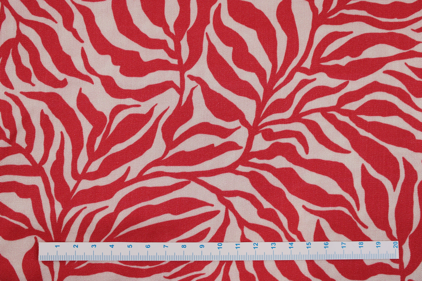 Viskosestoff Zebra Jungle mit Blätterprint in Koralle und Ecru Maßstab