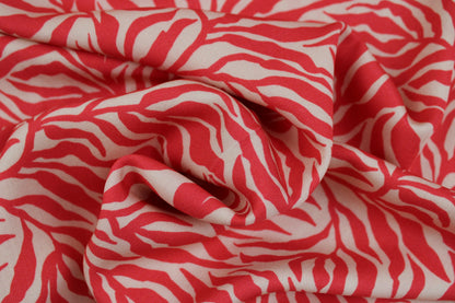 Viskosestoff Zebra Jungle mit Blätterprint in Koralle und Ecru gedreht