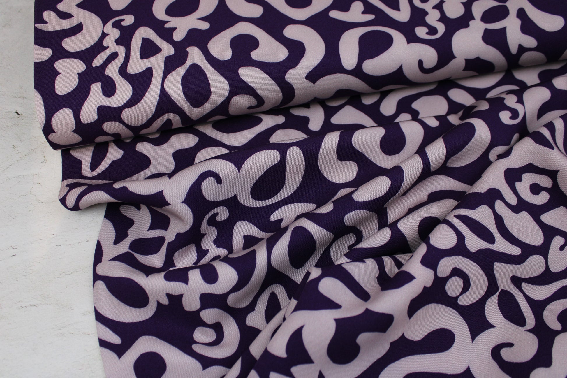 Viskosestoff mit abstraktem Muster in Lila und Flieder Ballenansicht