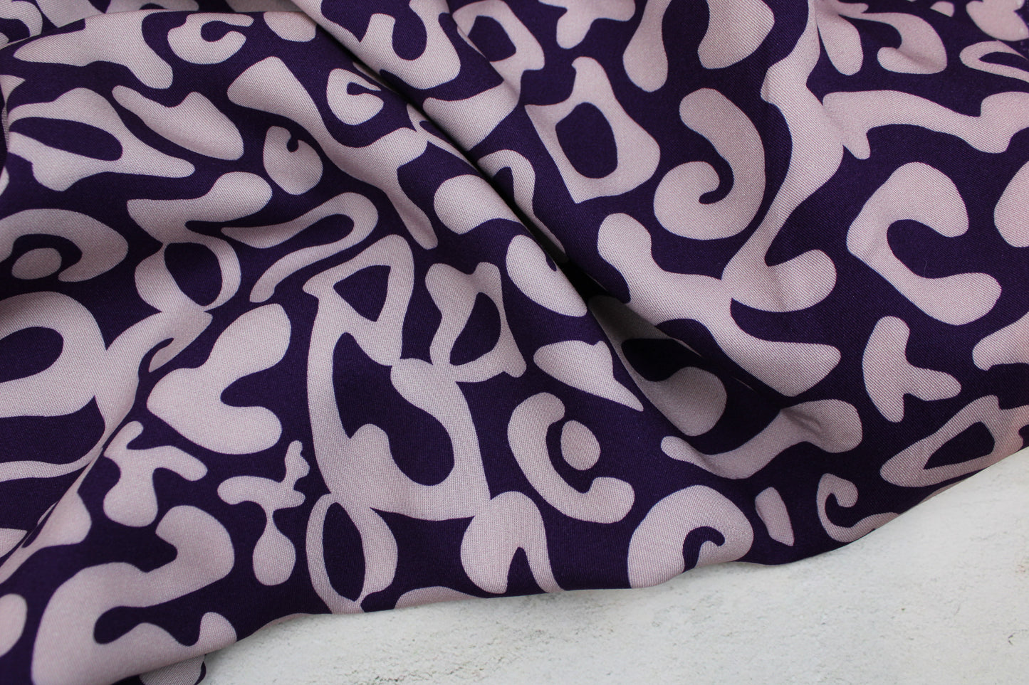 Viskosestoff mit abstraktem Muster in Lila und Flieder